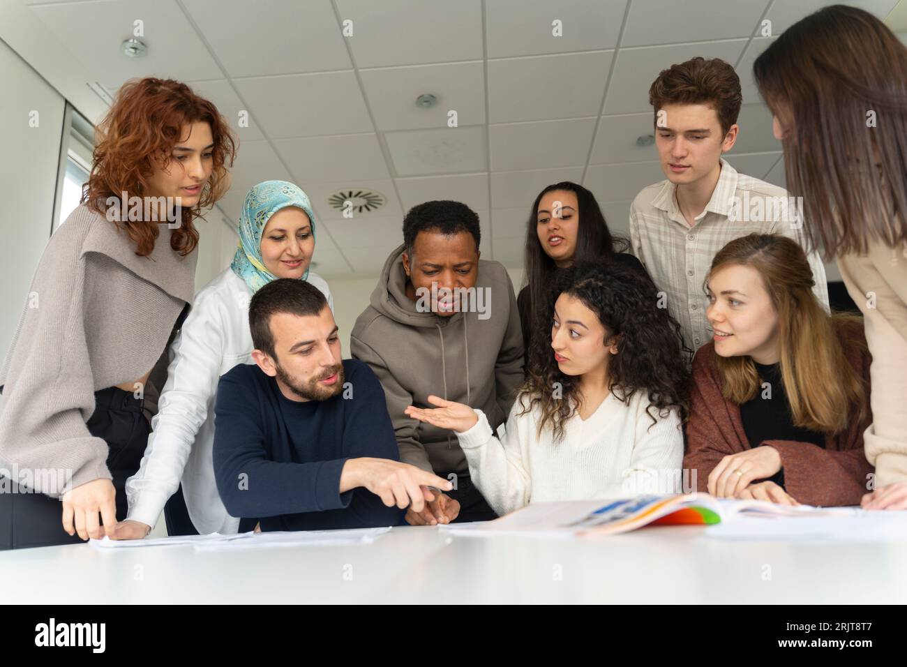Studenti che discutono con un libro in classe Foto Stock