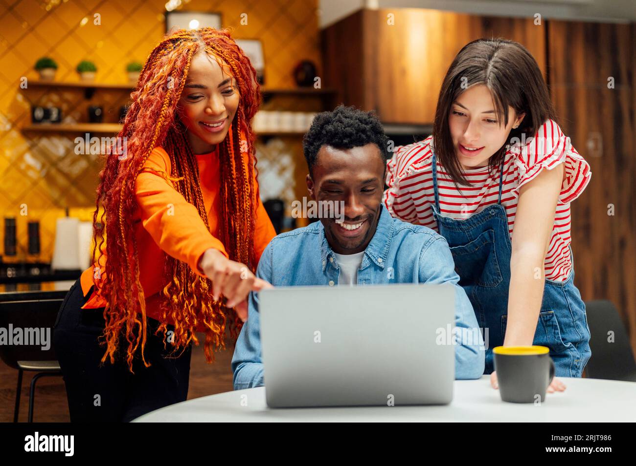 Donna d'affari che discute con i colleghi sul notebook in ufficio Foto Stock