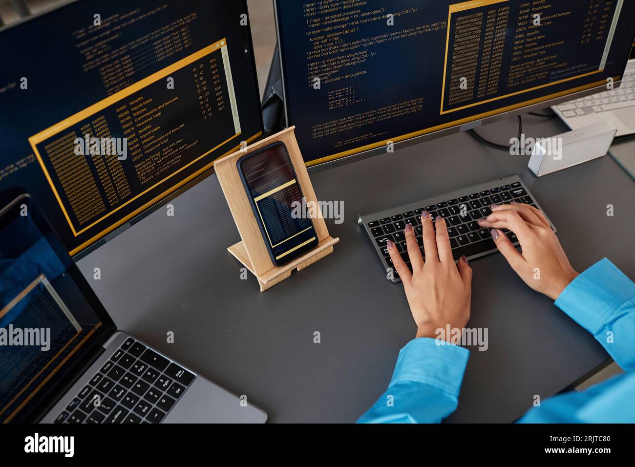 Mani di un programmatore di computer che digita sulla tastiera alla scrivania Foto Stock