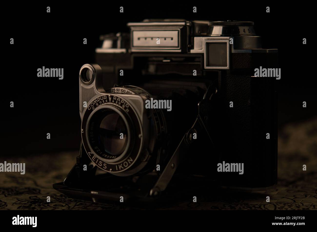 Primo piano di una vecchia fotocamera d'epoca con obiettivo Compur Rapid in un ambiente poco illuminato Foto Stock