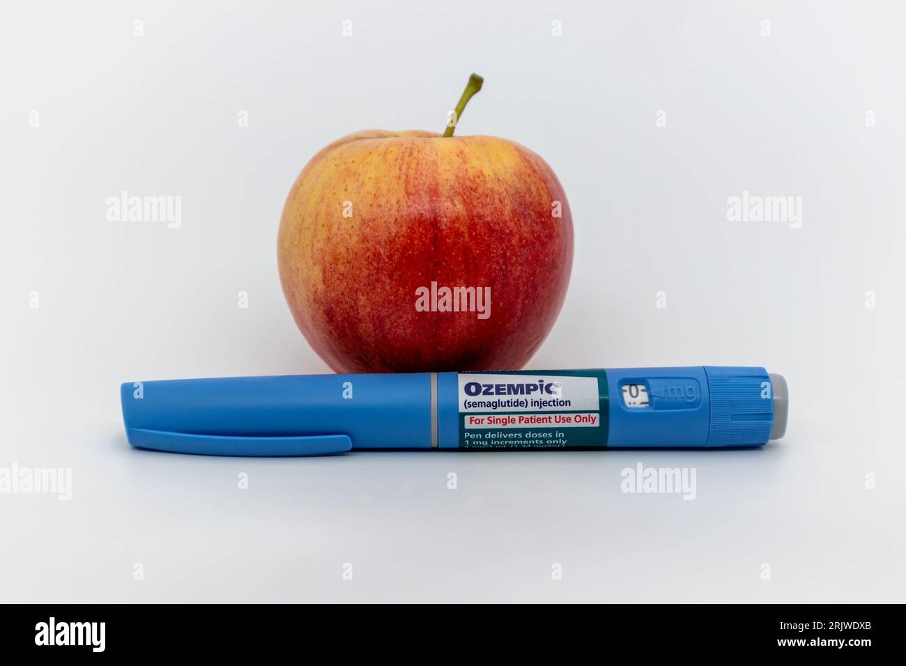 Penna Ozempic con mela su sfondo bianco con spazio per la copia Foto Stock