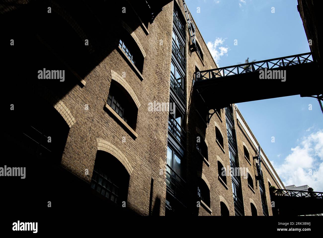 Un ponte che proietta ombre su un edificio nel molo di Londra Foto Stock