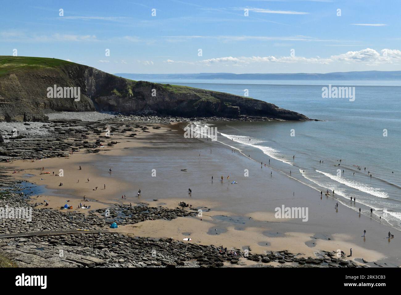 Guardando in basso la baia di Dunraven in un pomeriggio soleggiato di luglio con il Witches Point chiaramente in vista, insieme a molti appassionati di spiaggia che si divertono nel pomeriggio Foto Stock