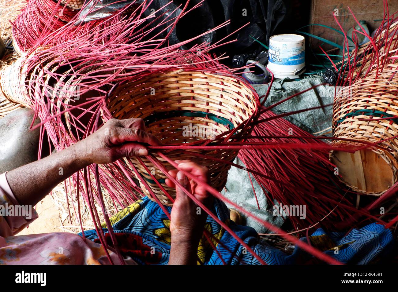 Le persone tessono un cesto domestico nel più grande villaggio di canne della Nigeria a Mende, nel Maryland District di Lagos. L'artigianato della canna da zucchero in Nigeria, il paese più popoloso dell'Africa, sta prosperando in mezzo a una crisi economica che ha colpito le piccole imprese e i guadagni delle persone. Nel villaggio, decine di persone, tra cui familiari e disoccupati, sono impegnate nella tessitura di diversi oggetti per la casa come tavoli, cesti, portabicchieri, vasi di fiori con legno di canna proveniente dalla palude regione del Delta del Niger. Lagos, Nigeria. Foto Stock