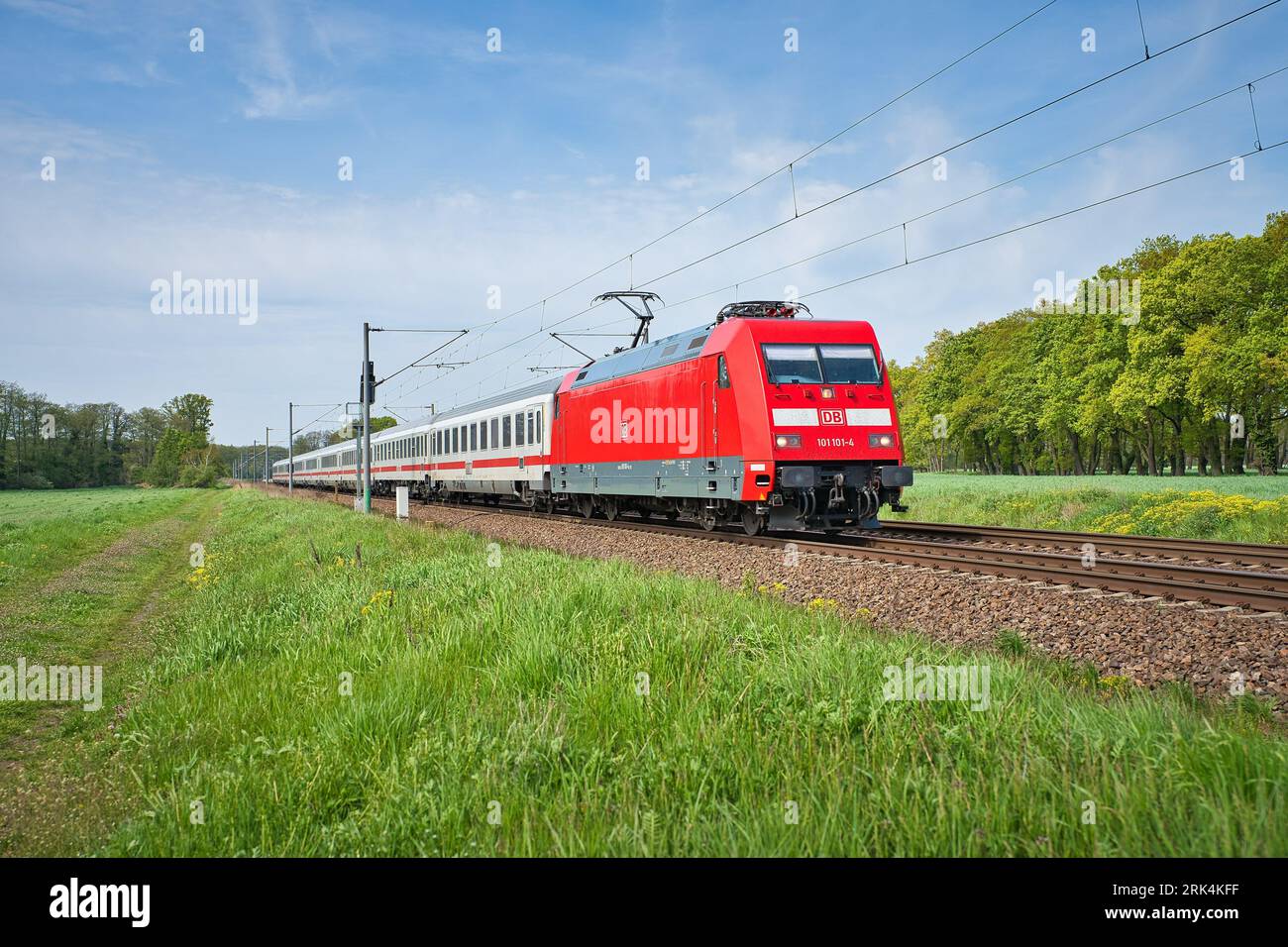 Un treno elettrico rosso che viaggia attraverso un paesaggio rurale panoramico a Gross Kreutz, Germania Foto Stock