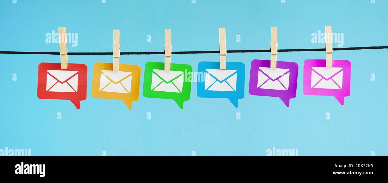 Newsletter e mailing list di marketing via e-mail e concept Internet con icona e simbolo e-mail bianche su carta colorata bolle vocali appese in blu Foto Stock