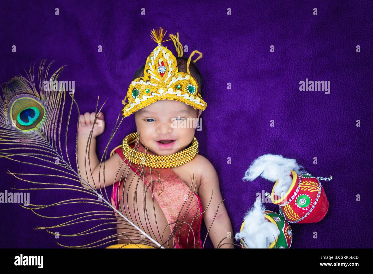 bambino neonato in krishna vestito con puntelli da una prospettiva unica e con espressioni diverse Foto Stock
