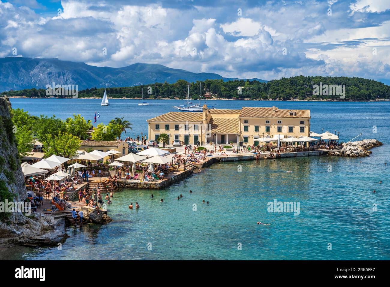 Vista dalla spiaggia balneabile di Faliraki e dal ristorante nella città vecchia di Corfù, isola di Corfù, Isole Ionie, Grecia Foto Stock