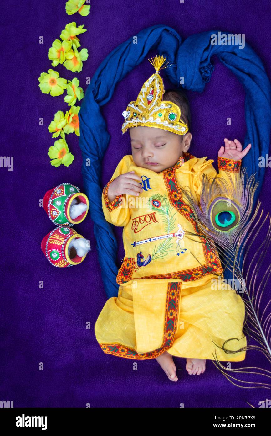 bambino neonato in krishna vestito con puntelli da una prospettiva unica e con espressioni diverse Foto Stock
