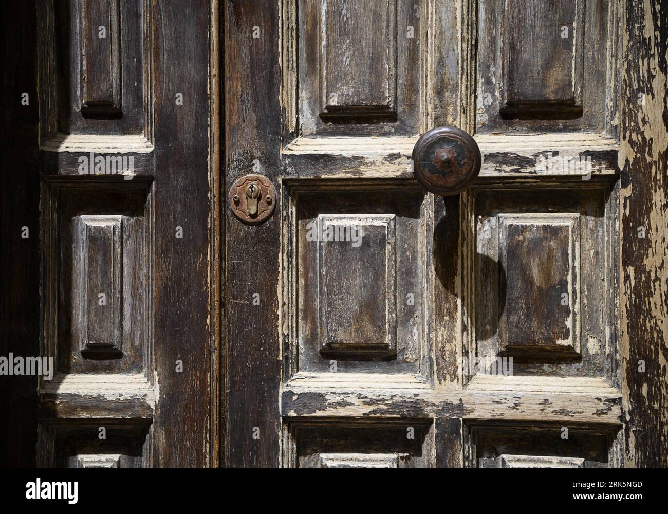 Antica porta in legno con maniglia arrugginita a Cefalù Sicilia, Italia. Foto Stock