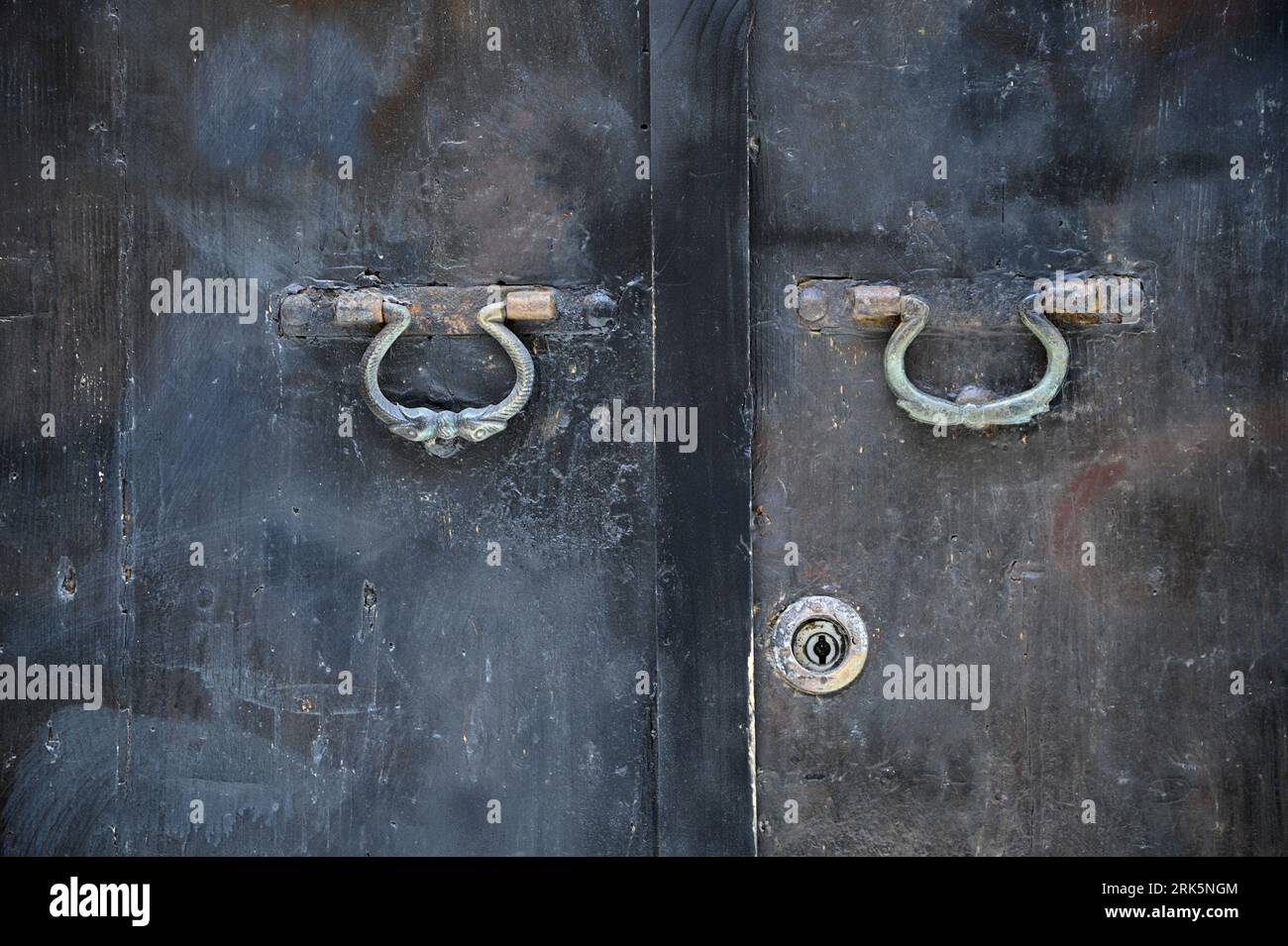 Porta in metallo antico con due chiusure di peltro d'epoca a Cefalù Sicilia, Italia. Foto Stock
