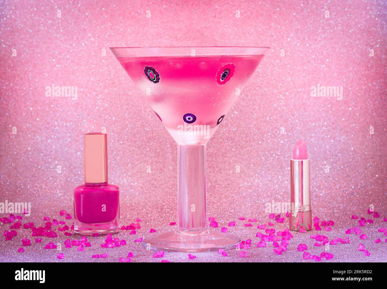Cocktail rosa con cosmetici rosa su sfondo scintillante Foto Stock