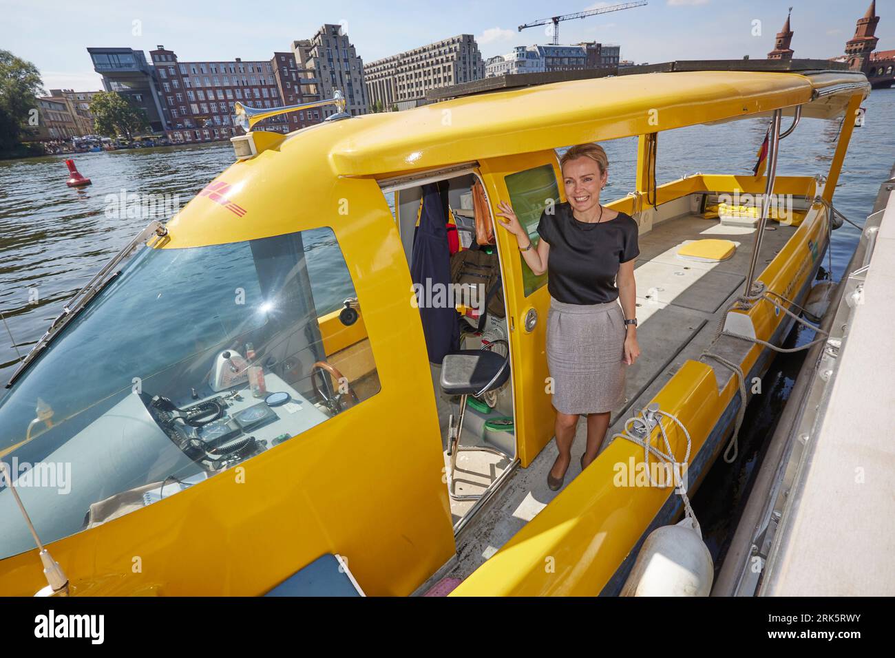 Berlino, Germania. 24 agosto 2023. Manja Schreiner (CDU), senatrice per i trasporti a Berlino, si trova a bordo di una nave solare DHL alimentata elettricamente. DHL Group amplierà ulteriormente il trasporto pacchi via acqua a Berlino. Il percorso esistente sui fiumi Sprea e Havel sarà ampliato e si sta progettando un secondo percorso da Köpenick a Osthafen. Credito: Jörg Carstensen/dpa/Alamy Live News Foto Stock