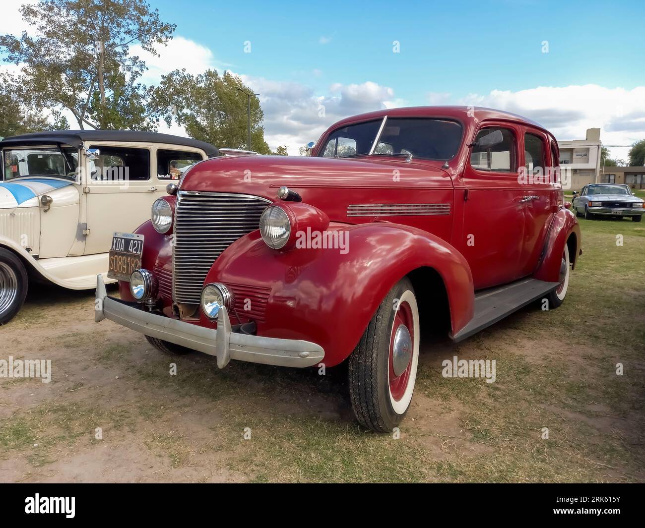 Vecchia Chevrolet Chevy Master berlina rossa del 1939 a quattro porte della General Motors sul prato. Natura, erba, alberi. Mostra di auto d'epoca CAACMACH 2023. Foto Stock