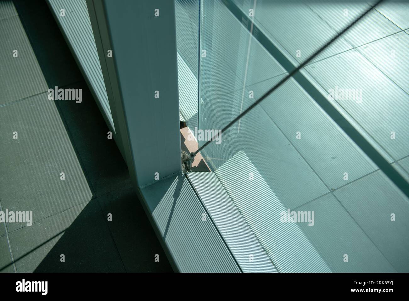 architettura, dettaglio di costruzione di un edificio con tiranti in corda d'acciaio per controventare e vetro serigrafato per ridurre i raggi solari. bui moderno Foto Stock