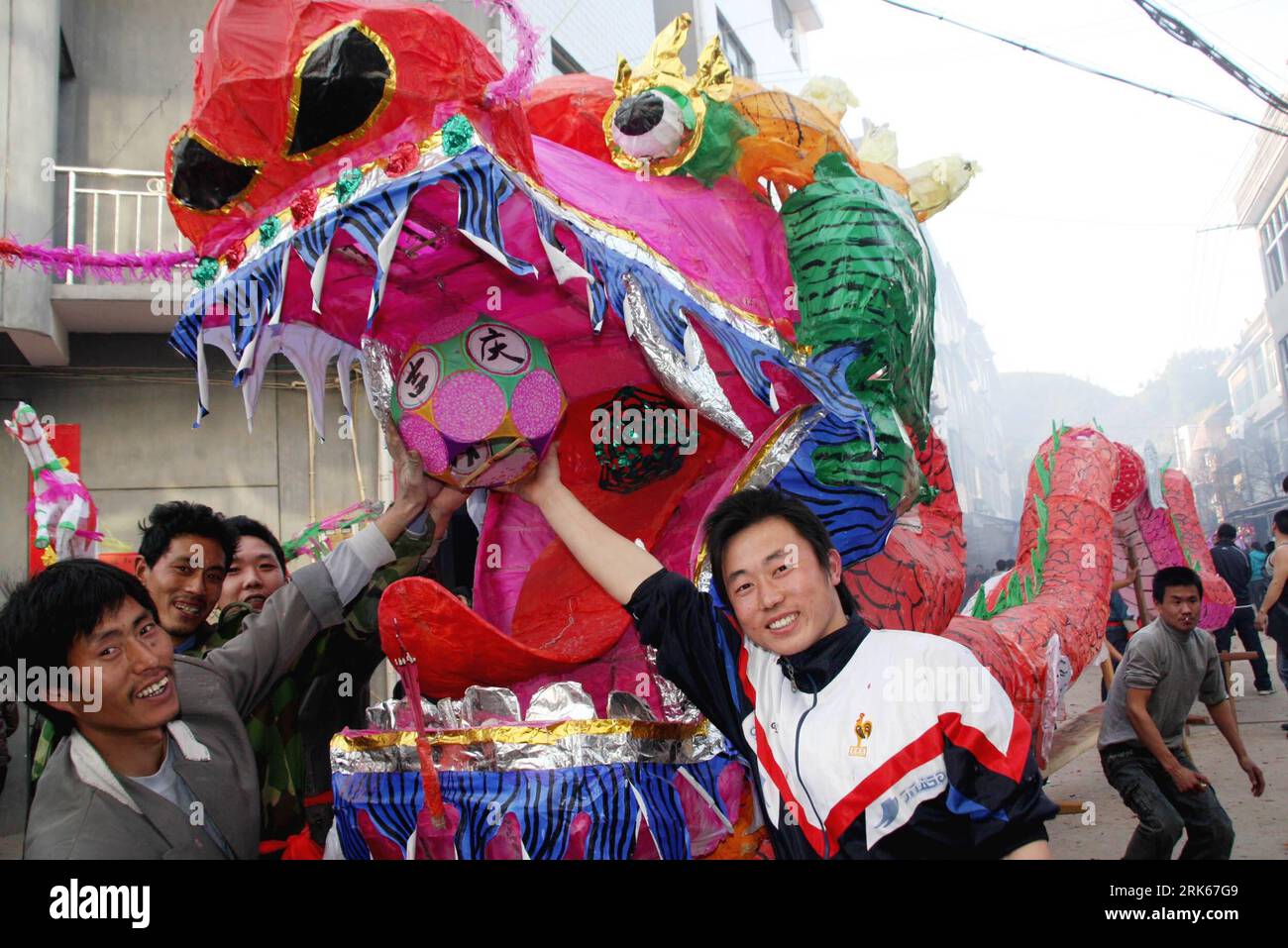 Bildnummer: 53809775 Datum: 20.02.2010 Copyright: imago/Xinhua (100221) -- DEXING, 21 febbraio 2010 (Xinhua) -- i contadini locali toccano il cordone nella bocca del gigantesco drago di sgabello di legno per buona fortuna nel villaggio di Zhancai di Dexing City, provincia di Jiangxi, 20 febbraio 2010. Più di 500 agricoltori hanno salutato insieme un drago di legno lungo 500 metri e hanno fatto un giro per la città il sabato, una tradizione locale di benedizione durante il Festival di Primavera. (Xinhua/Zhuo Zhongwei) (zgp) (CN) PUBLICATIONxNOTxINxCHN Festival kbdig xcb 2010 quer o0 chinesisches Frühlingsfest Drache Bildnummer 53809 Foto Stock