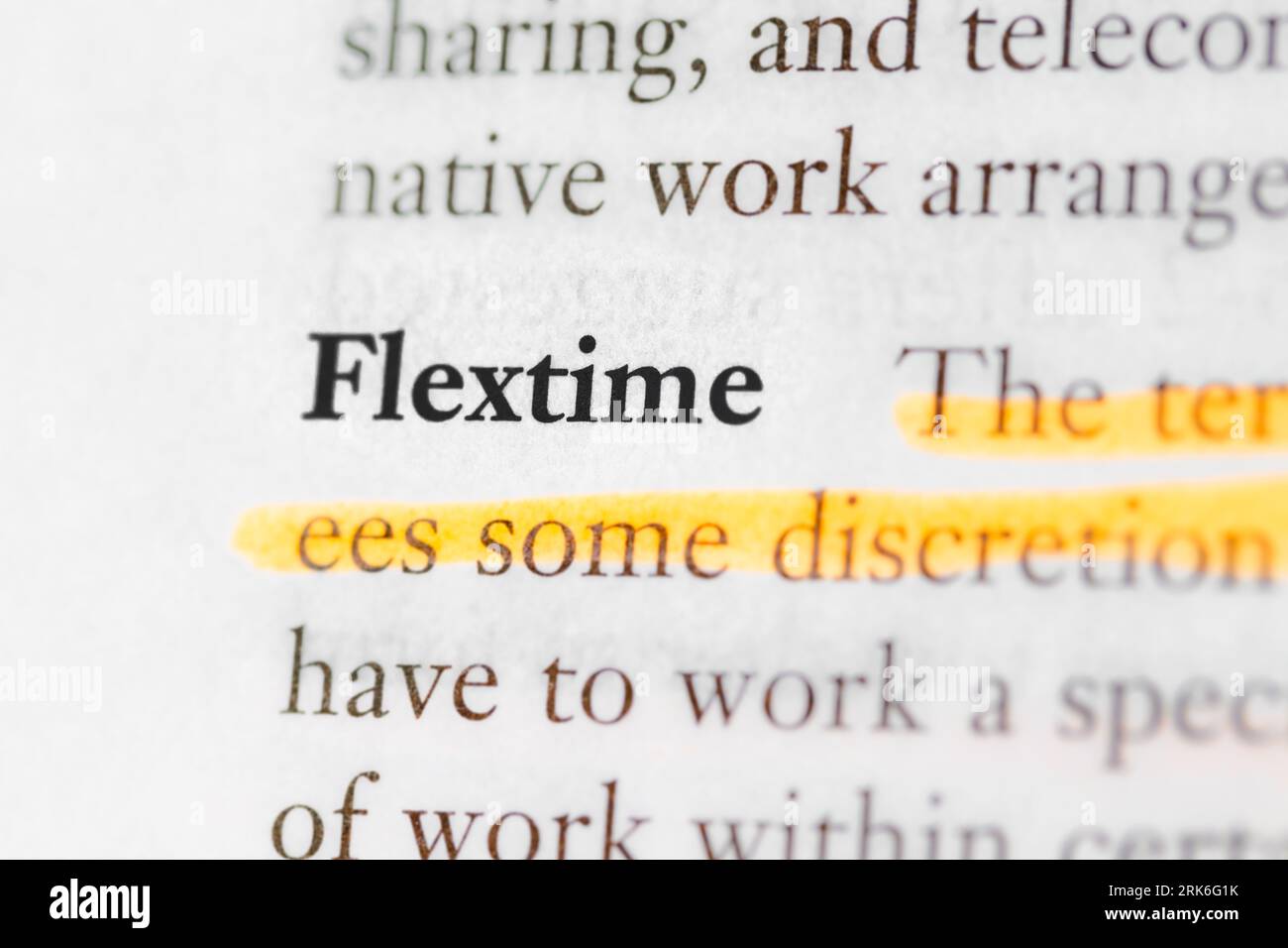 Primo piano di un libro di testo aziendale con il termine "flextime" evidenziato e concentrato Foto Stock