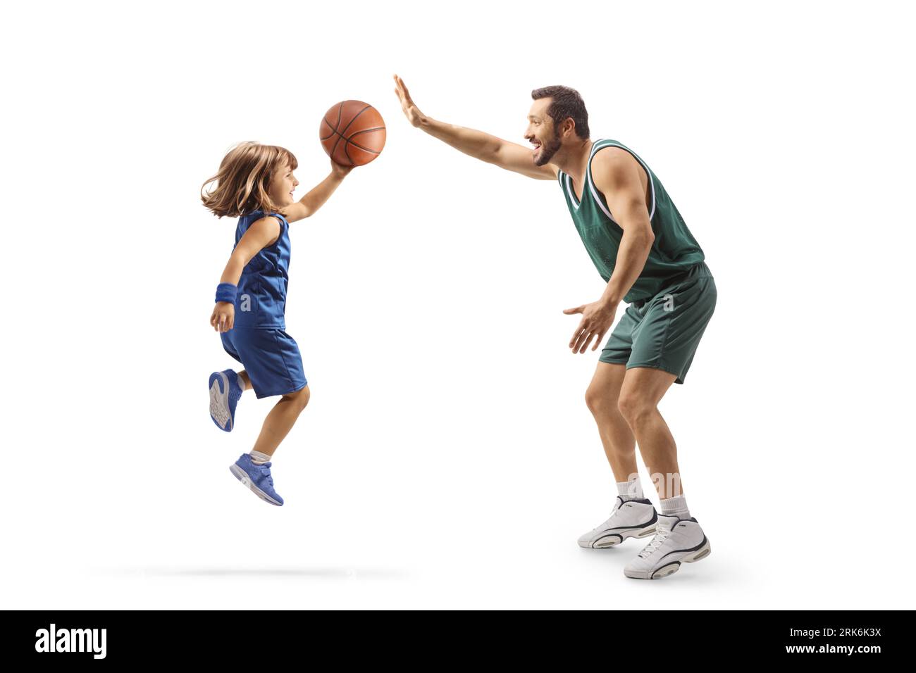 Ragazza che gioca a basket con un giocatore professionista di basket isolato su sfondo bianco Foto Stock