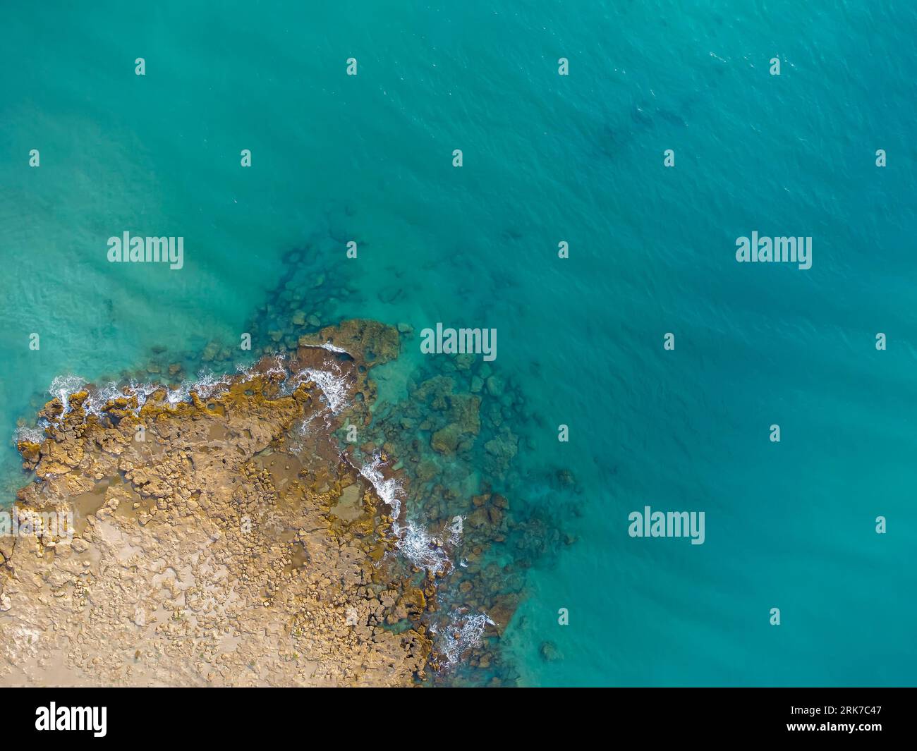 vista dall'alto di una sporgenza rocciosa, in un mare di acque turchesi cristalline, promontorio roccioso, costa, vista droni, spazio fotocopie Foto Stock