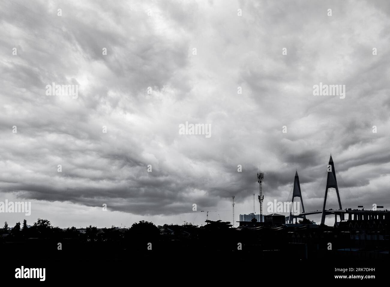 The silhouette of Bhumiphol bridge on a cloudy day in Bangkok, Thailand in grayscale Foto Stock