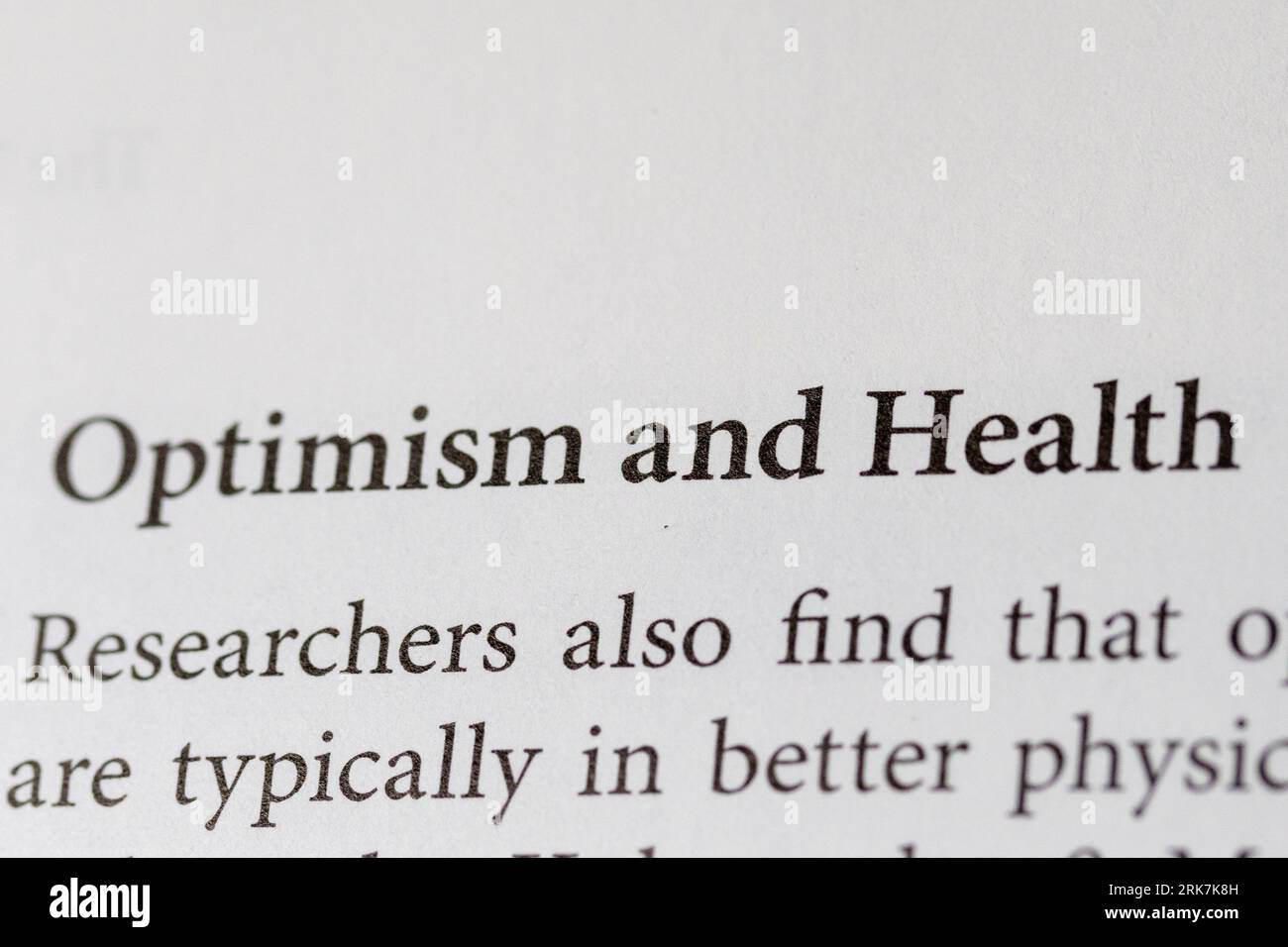 Un primo piano in alto di due parole, "ottimismo" e "salute", scritto con inchiostro nero su uno sfondo bianco nitido Foto Stock