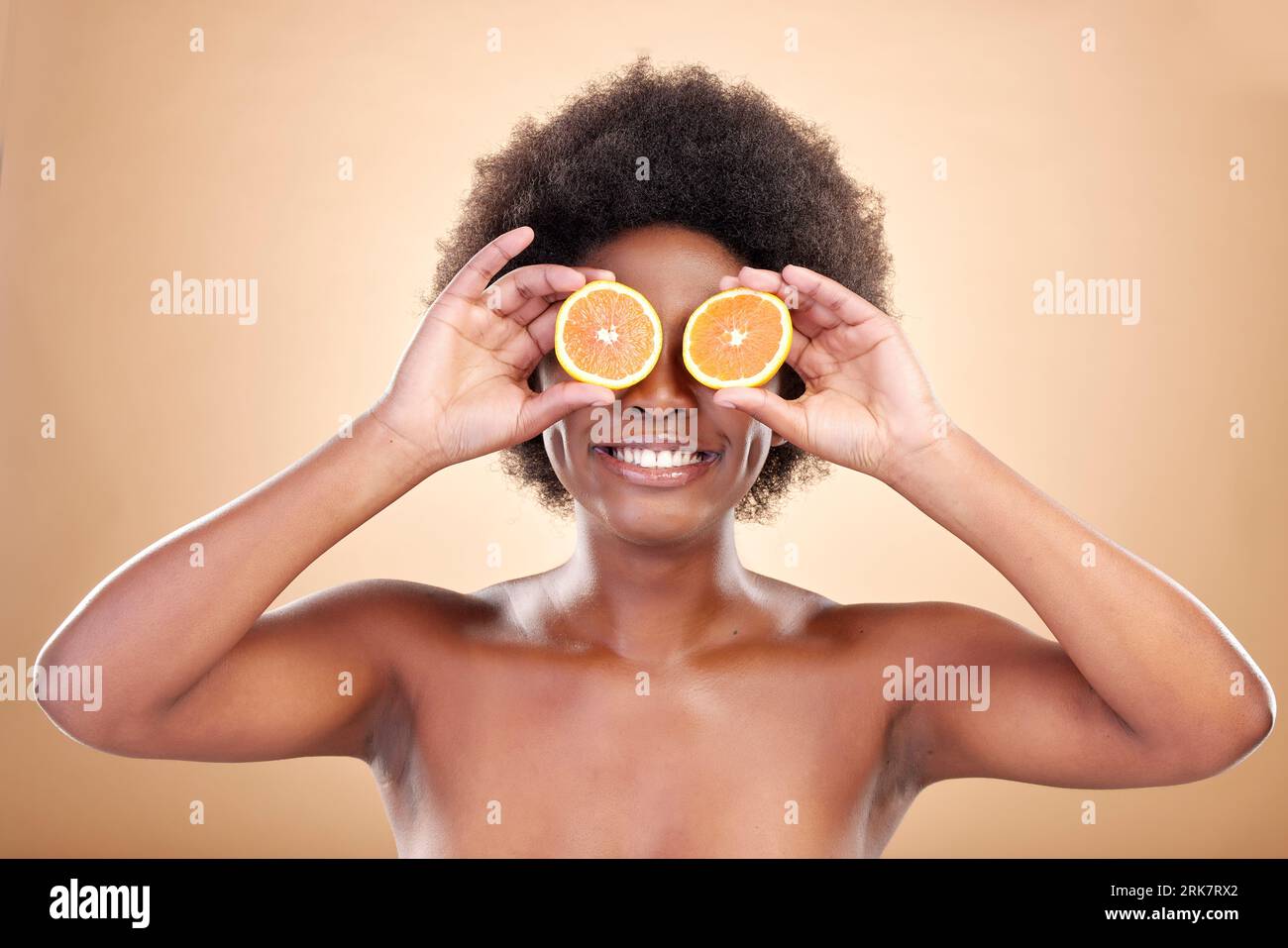 Frutti d'arancia, cura della pelle e donna sullo sfondo dello studio per cosmetici naturali, benefici sani e nutrizione. Il modello Happy african Beauty copre gli occhi Foto Stock