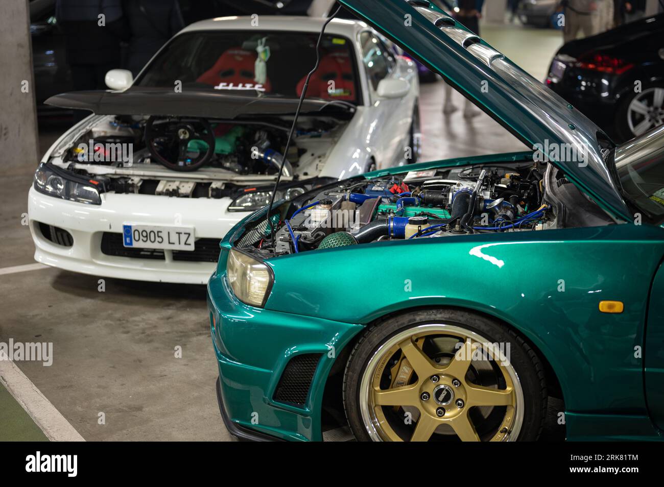 Detail of two emblematic and iconic cars of Japanese motorsports, the white Nissan Silvia S15 and the green Nissan GT-R 34 with the hood open Foto Stock
