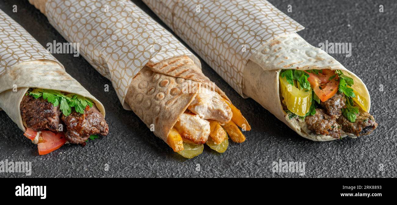 Tre deliziosi involtini ripieni di carne salata e verdure fresche, impilati l'uno sull'altro Foto Stock