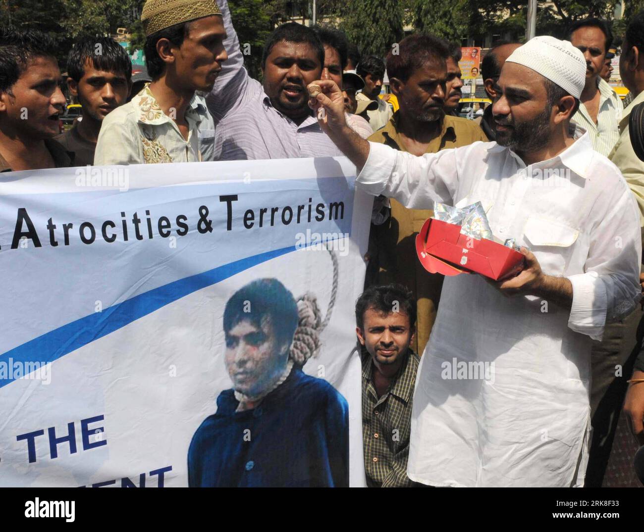 Bildnummer: 54030105 Datum: 06.05.2010 Copyright: imago/Xinhua Un uomo distribuisce dolci per celebrare la condanna a morte contro l'aggressore di Mumbai Mohammed Ajmal Amir alias Kasab a Mumbai, India, 6 maggio 2010. L'aggressore di Mumbai Mohammed Ajmal Amir alias Kasab è stato condannato giovedì a morte nel caso di attentati terroristici di Mumbai da un tribunale speciale indiano, tre giorni dopo essere stato condannato per omicidio e guerra contro lo stato durante la carneficina di 62 ore. (Xinhua/Stringer)(zl) (5)INDIA-MUMBAI ATTACKS-KASAB-DEATH PUBLICATIONxNOTxINxCHN People Politik Terror Terroranschlag A. Foto Stock