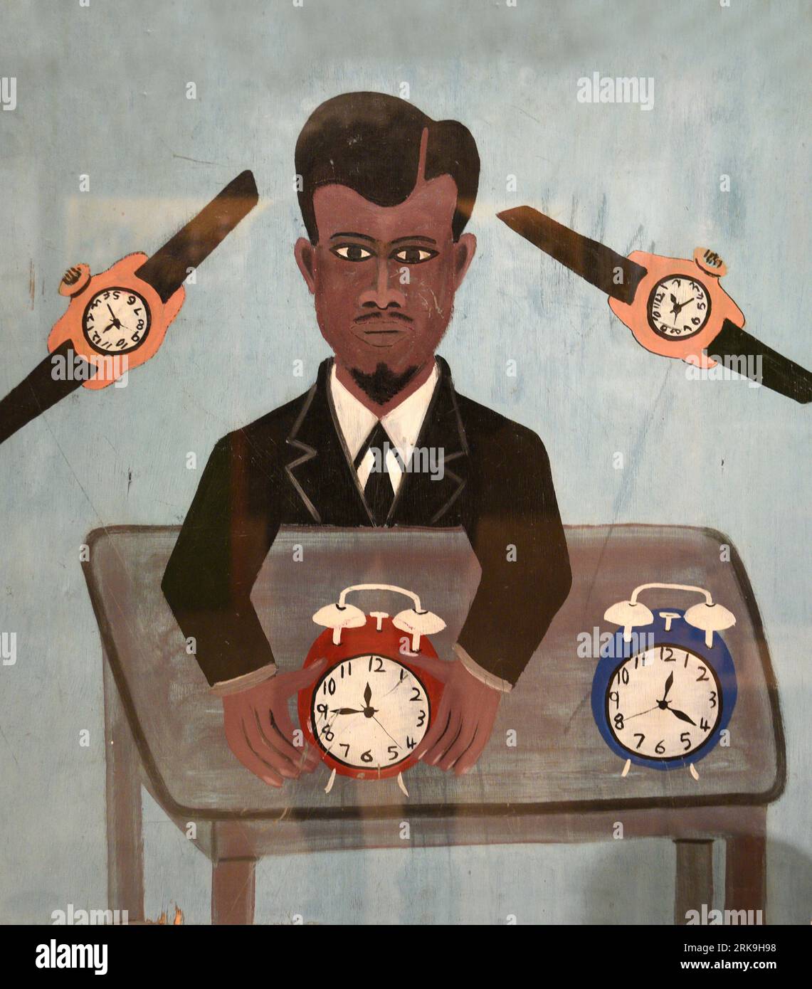 Un orologio dipinto a mano e un cartello di riparazione dell'orologio realizzato da un artista africano in mostra all'International Folk Art Museum di Santa Fe, New Mexico. Foto Stock
