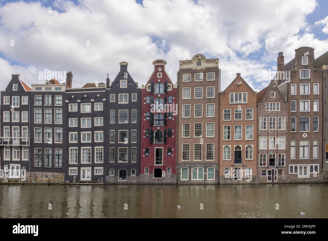 Edifici cittadini di Amsterdam lungo i canali nei Paesi Bassi, con facciate colorate, timpani storici e classiche case cittadine olandesi. Foto Stock