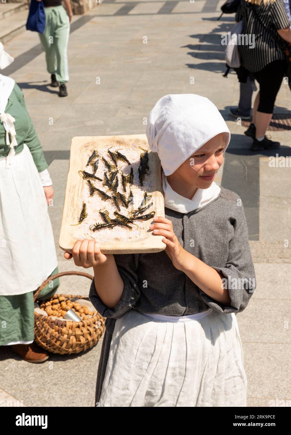 Reenactor adolescente vestita da venditore di strada medievale al Targ Rybny o al mercato del pesce nella città vecchia di Danzica, in Polonia Foto Stock
