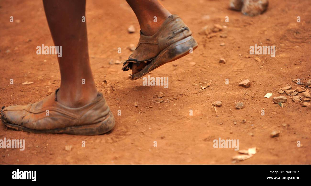 Bildnummer: 54245295 Datum: 21.07.2010 Copyright: imago/Xinhua (100722) -- NAIROBI, 22 luglio 2010 (Xinhua) -- Uno studente che indossa scarpe rotte gioca nel piccolo cortile della scuola di salvataggio di Stara a Kibera di Nairobi, capitale del Kenya, il 21 luglio 2010. La scuola di salvataggio Stara è stata fondata nel 2000 nella baraccopoli di Kibera a Nairobi. Quarantotto bambini su circa 500 nella scuola di soccorso di Stara sono stati diagnosticati con HIV/AIDS e attualmente sono sotto farmaci antiretrovirali. Circa il 70 per cento dei bambini della scuola sono orfani dall'AIDS, il 10 per cento di loro è trascurato e abusato, mentre un altro 5 per cento com Foto Stock