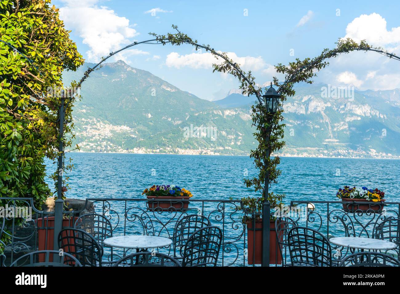 Sole sul versante montano del Lago di Como attraverso vigneti su archi sul bordo del lago di Menaggio, Italia sulle rive del Lago di Como. Foto Stock