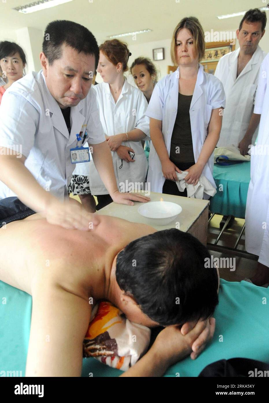 Bildnummer: 54274993 Datum: 04.08.2010 Copyright: imago/Xinhua (100804) -- SHENYANG, 4 agosto 2010 (Xinhua) -- Un medico cinese insegna massaggio cinese a insegnanti e studenti francesi nell'ospedale di medicina tradizionale cinese di Shenyang, capitale della provincia di Liaoning della Cina nord-orientale, 4 agosto 2010. Circa 10 insegnanti e studenti del National College of Traditional Chinese Medicine in Francia impareranno a conoscere l'agopuntura e la terapia moxibustion, il massaggio cinese e altri trattamenti di medicina cinese durante la formazione di 2 settimane. (Xinhua/Yang Xinyue)(whj) #CHINA-SHENYANG-CHINESE MEDICIN Foto Stock