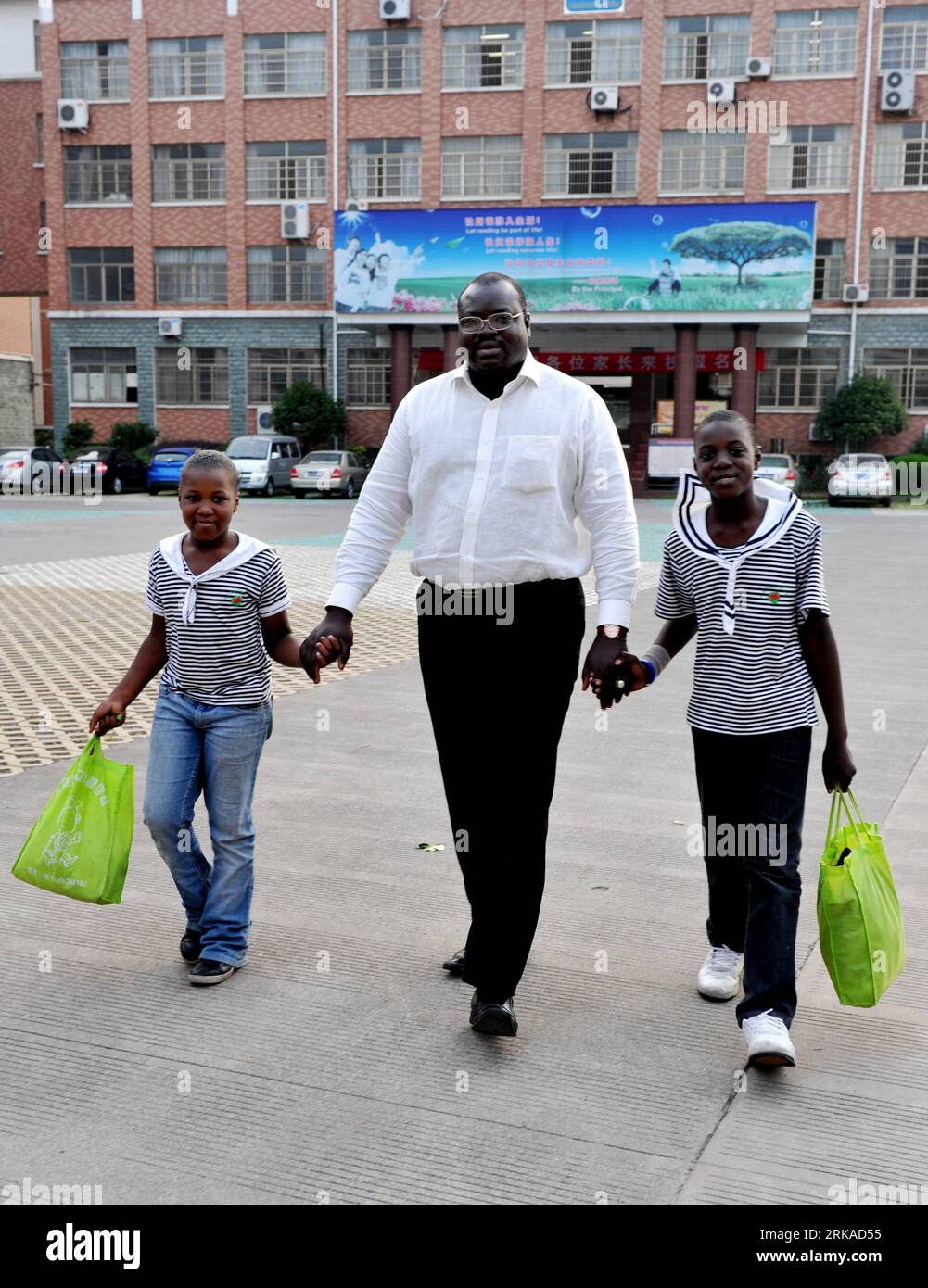 Bildnummer: 54320186 Datum: 19.08.2010 Copyright: imago/Xinhua (100819) - JINHUA, 19 agosto 2010 (Xinhua) - Mamadou Sall, un commerciante senegalese, porta i suoi figli a casa dalla scuola di Yiwu, nella provincia dello Zhejiang, nella Cina orientale, 3 giugno 2010. Mamadou Sall, che aveva fatto affari negli Stati Uniti per dieci anni, si è trasferito a Zhejiang S Yiwu, un mercato all'ingrosso di piccole materie prime leader a livello mondiale, nel 2001, per avviare una società che gestiva l'attività di abbigliamento e tessuti dalla Cina ai paesi africani. Mamadou fece un buon lavoro nel suo lavoro e portò sua moglie e i suoi figli in Cina nel 2005. Nel 200 Foto Stock