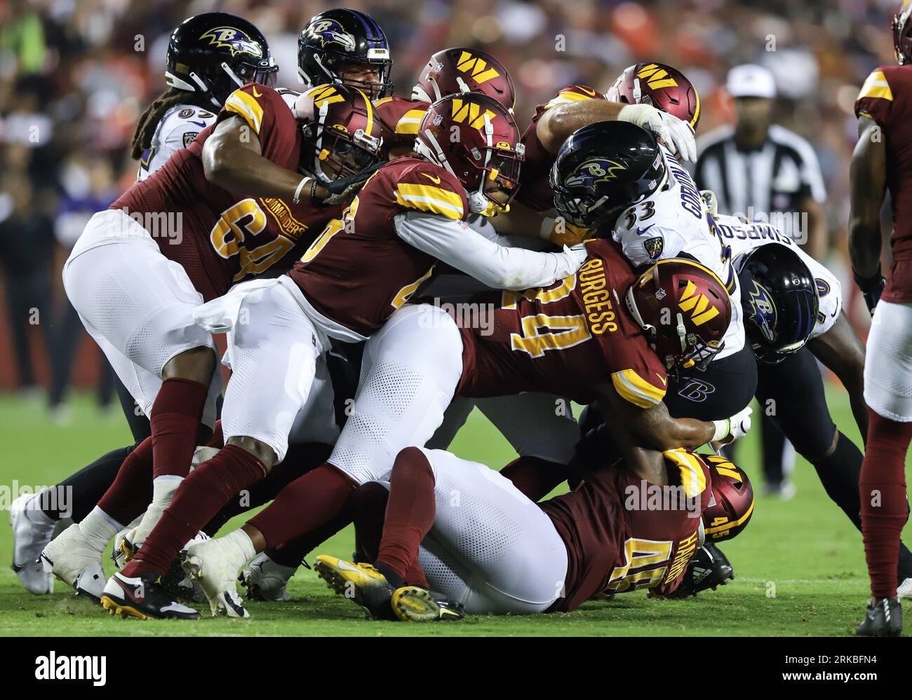 Baltimore Ravens RB Melvin Gordon III (33) fu placcato dopo il carry dai Washington Commanders Terrell Burgess (24) e LB De'Jon Harris (45) durante la gara di pre-stagione della settimana 2 contro i Washington Commanders al FedEx Field di Landover MD il 21 agosto 2023 (Alyssa Howell/Image of Sport) Foto Stock