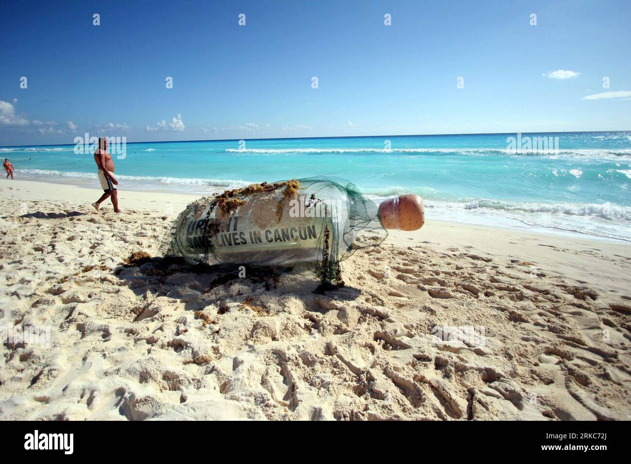Bildnummer: 54683335 Datum: 28.11.2010 Copyright: imago/Xinhua (101128) -- CANCUN, 28 novembre 2010 (Xinhua) -- Un turista cammina davanti a una bottiglia gigante su una spiaggia mostrando un messaggio che dice urgente, salvare vite a Cancun , nella località caraibica di Cancun, Messico, 28 novembre 2010. Il messaggio è stato inviato da Oxfam International per attirare l'attenzione della Conferenza delle Nazioni Unite sui cambiamenti climatici (COP-16) che si terrà qui dal 29 novembre al 10 dicembre. (Xinhua/Elizabeth Ruiz) (wjd) MESSICO-CANCÚN-SUMMIT SUL CLIMA-BOTTIGLIA-MESSAGGIO PUBLICATIONxNOTxINxCHN Gesellschaft protesta Luftverschmutzung Klimaschutz Foto Stock