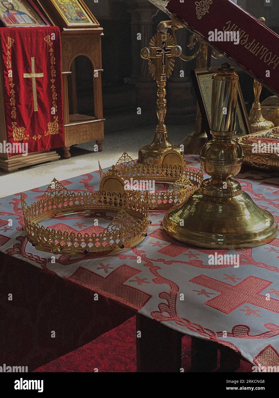 Un tavolo dorato ornato con oggetti decorativi si erge in modo prominente di fronte a un altare in un ambiente ritualistico Foto Stock