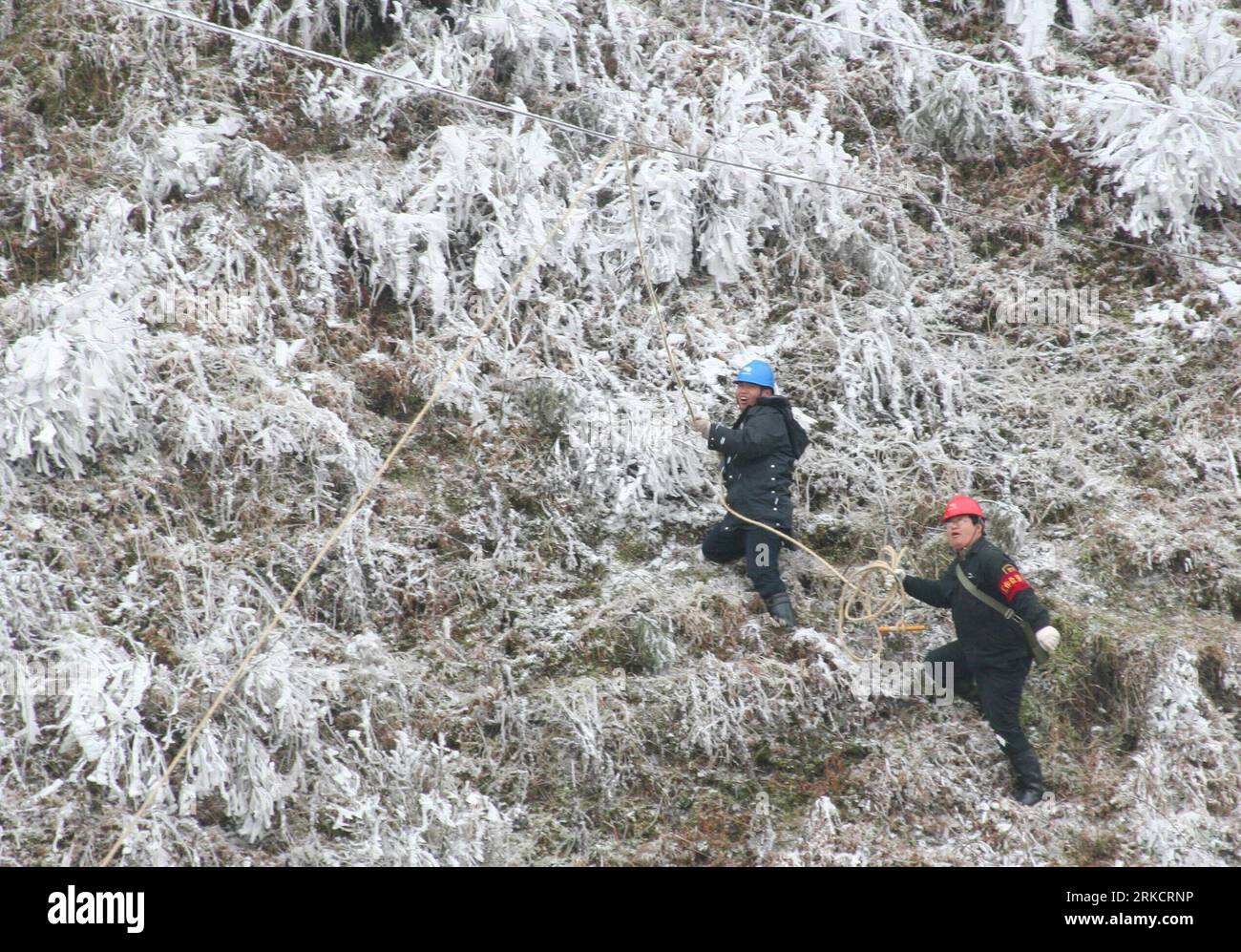 Bildnummer: 54797768 Datum: 10.01.2011 Copyright: imago/Xinhua (110110) -- LIUPANSHUI, 10 gennaio 2011 (Xinhua) -- i lavoratori puliscono il ghiaccio sul cavo di alimentazione a Liupanshui, nella provincia di Guizhou della Cina sud-occidentale, 10 gennaio 2011. Molti luoghi a Guizhou hanno visto il freddo negli ultimi giorni. La neve e il ghiaccio hanno disturbato il traffico e l'alimentazione. Un fronte freddo porterebbe più pioggia ghiacciata e neve nella Cina meridionale dal 9 al 13 gennaio, congelando parti del sud della Cina già colpite da temperature inferiori allo zero dal giorno di Capodanno, hanno detto le autorità meteorologiche. (Xinhua/Huang Shujin) (xzj) CHINA-GUIZHOU-ICE AN Foto Stock