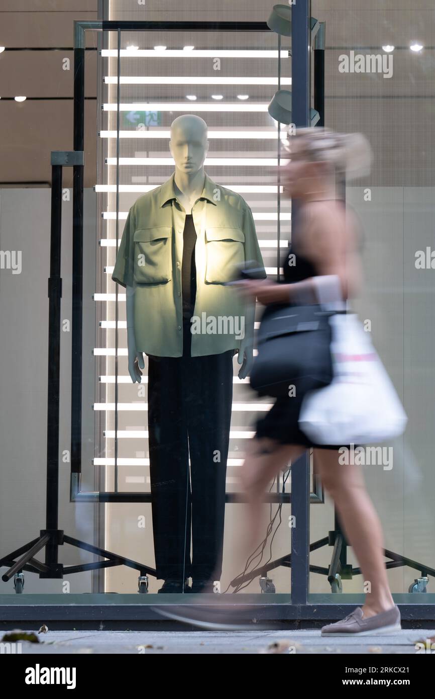 Dresda, Germania. 24 agosto 2023. Un passante passeggia davanti alla finestra di un negozio di moda in una zona pedonale. L'Ifo Business Climate Index è pubblicato il 25.08.2023. Credito: Sebastian Kahnert/dpa/Alamy Live News Foto Stock