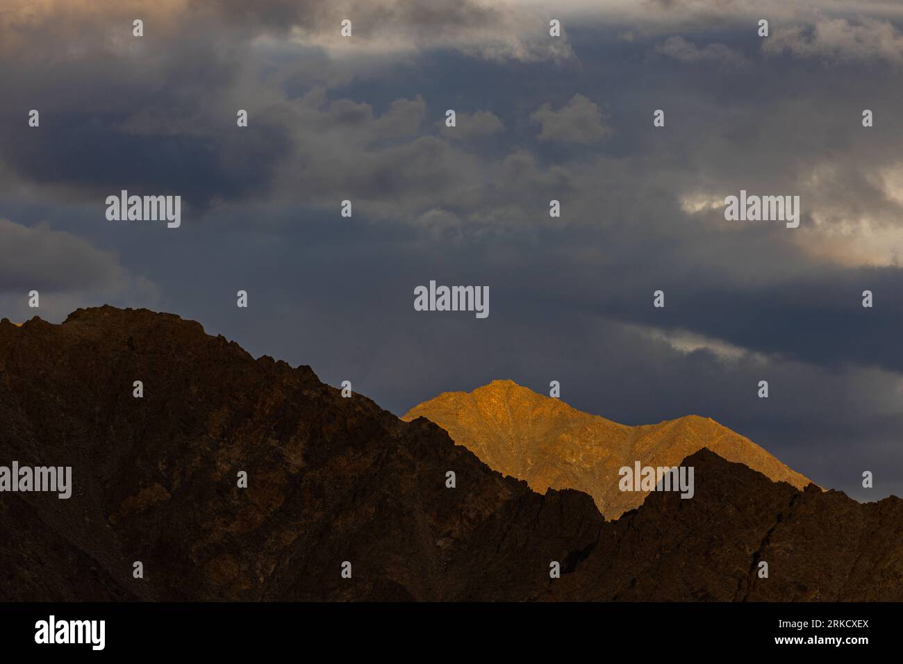 Una vista spettacolare delle montagne con i raggi del sole che cadono tra le nuvole Foto Stock