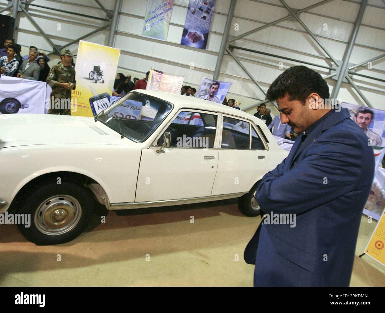 Bildnummer: 54970491 Datum: 01.03.2011 Copyright: imago/Xinhua (110302) -- TEHERAN, 2 marzo 2011 (Xinhua) -- l'avvocato del compratore, si trova accanto all'auto del presidente iraniano durante l'International Car Exhibition nella zona franca di Arvand nel sud-ovest dell'Iran, 1 marzo 2011. L'auto del presidente iraniano Mahmoud Ahmadinejad, una Peugeot 504 bianca del 1977, è stata venduta martedì a quasi 2,5 milioni di dollari USA in un'asta per raccogliere fondi per un progetto di edilizia durante un'esposizione internazionale dell'automobile. (Xinhua/Ahmad Halabisaz) (jl) IRAN-TEHERAN-PRESIDENT-CAR-AUCTION PUBLICATIONxNOTxINxCHN People Politik premiumd Foto Stock