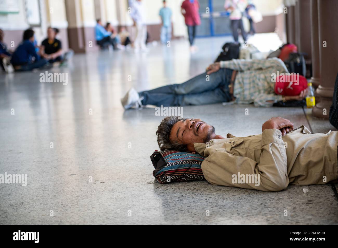 Bangkok, Bangkok, Thailandia: Una vista sincera della sala d'ingresso della stazione ferroviaria di Bangkok, che mostra i senzatetto che dormono sul pavimento. Foto Stock
