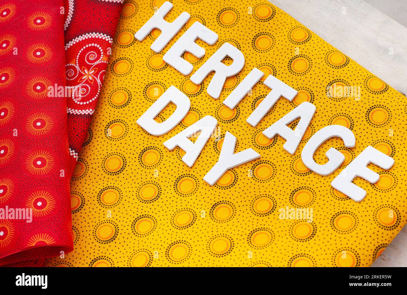 Heritage Day Sudafrica. Heritage Day scritto in lettere bianche con iconico tessuto stampato sudafricano Foto Stock