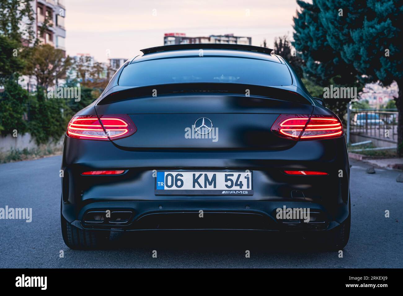 Mercedes Benz C63s AMG nera al tramonto della città. Foto Stock