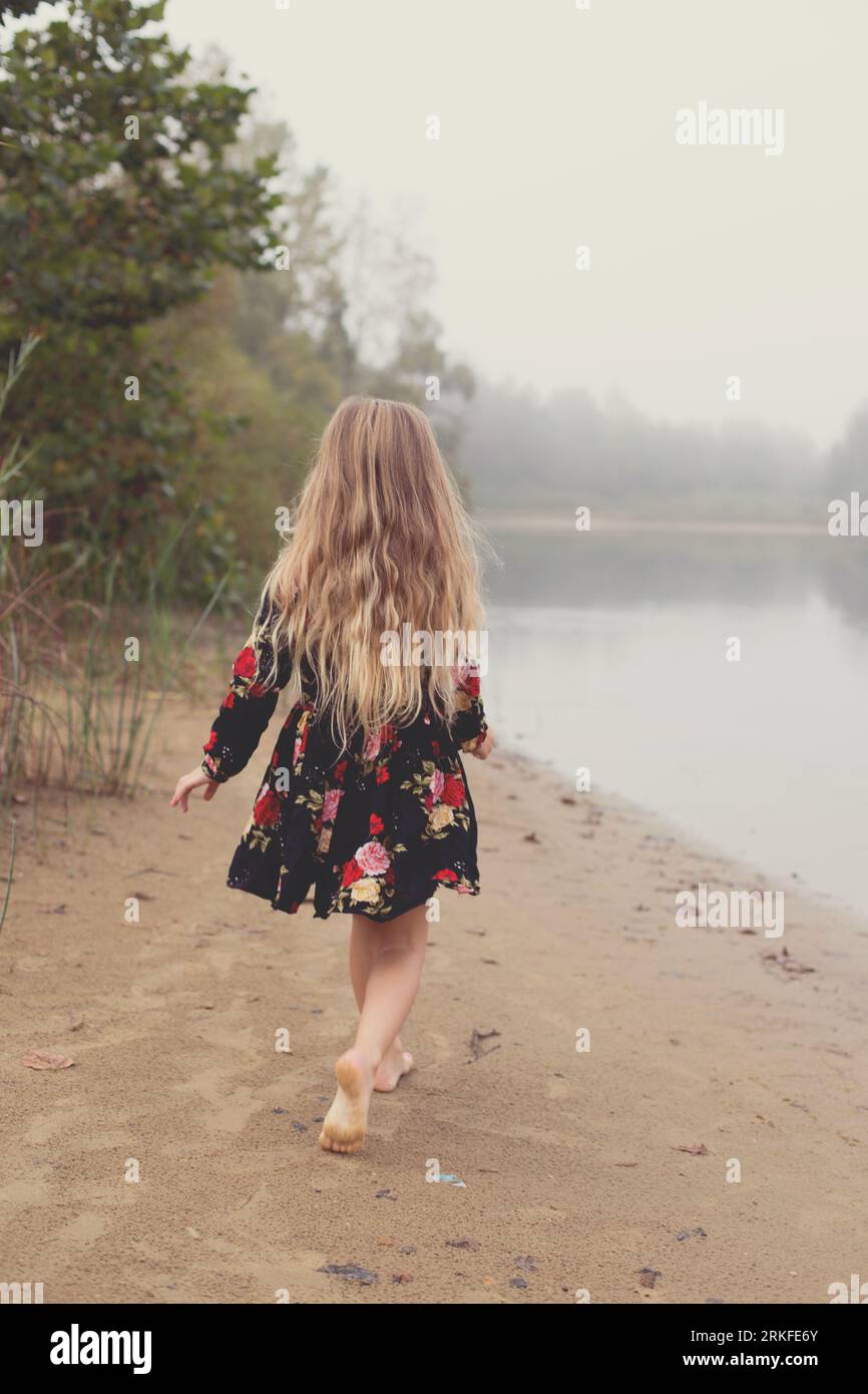 La bambina vaga da sola attraverso la nebbia Foto Stock