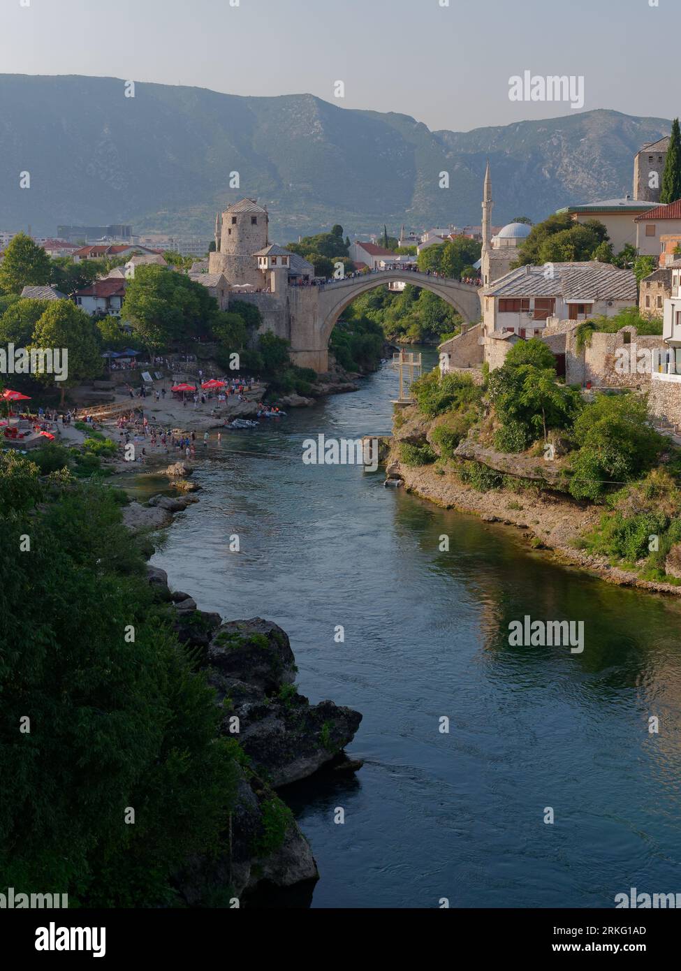 Lungofiume e spiaggia lungo il fiume Neretva e Stari Most (Ponte Vecchio) nella città di Mostar, Bosnia ed Erzegovina, 20 agosto 2023. Foto Stock