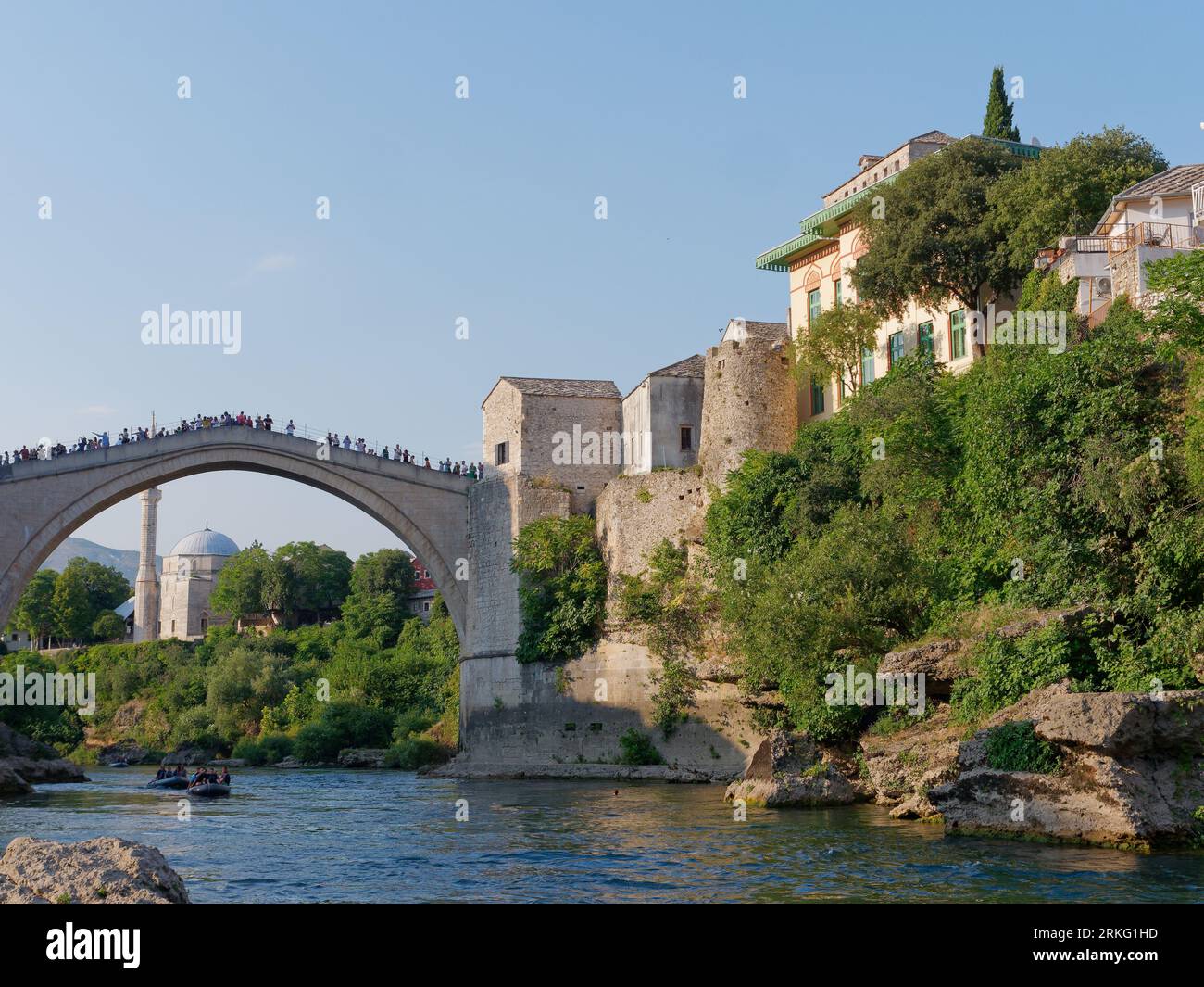 Fiume Neretva e Stari Most (Ponte Vecchio) con la Moschea Koski-Mehmed Pasha alle spalle a Mostar, Bosnia ed Erzegovina, 20 agosto 2023. Foto Stock