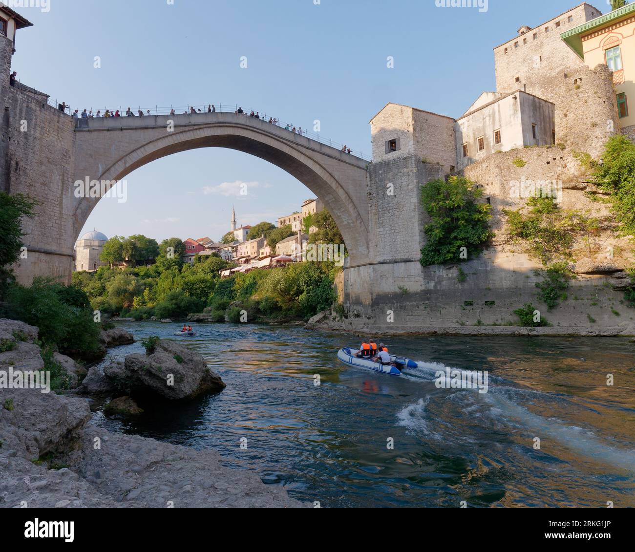 Motoscafi sul fiume Neretva con turisti a Stari Most (Ponte Vecchio) a Mostar, Bosnia ed Erzegovina, 20 agosto 2023. Foto Stock
